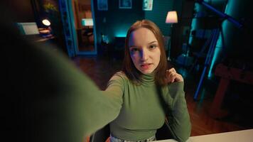 POV of social media star using smartphone camera to capture welcoming intro for vlogging channel. Girl in home studio connects with loyal fans during livestream, filming with phone on selfie stick photo