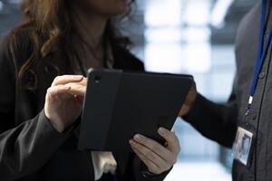 Team of technicians in data center using tablet to develop disaster recovery plans. Teamworking colleagues in server hub testing failover scenarios, protecting data during disruptions, closeup photo