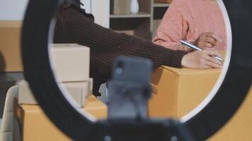 A woman is holding a pen and writing on a piece of paper video
