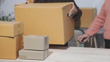 Two people are moving boxes around a table video