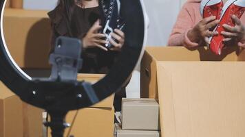 A woman holding a camera and a shoe box video