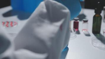 A person in a lab coat is holding a vial video