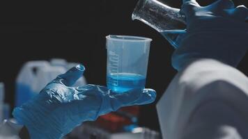 A person in a lab coat holding a beaker video