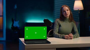 Tech expert presenting chroma key isolated screen laptop in entry level low budget price range. Gen Z influencer reviewing green screen notebook in front of internet subscribers, camera A photo