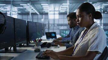 Close up of programmer in data center implementing AI predictive maintenance systems. Focus on IT professional in server hub using artificial intelligence to identify hardware failures, camera A photo