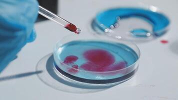 A person holding a test tube with a red liquid video