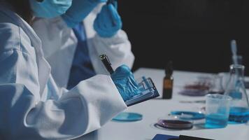 Two people in lab coats and masks working on something video