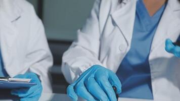 Two doctors in blue gloves and blue gloves are working on a clipboard video