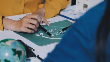 A person is writing on a piece of paper with a globe video