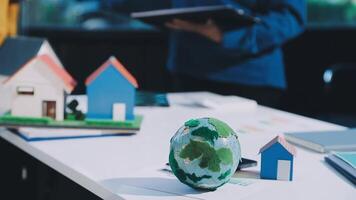 Earth model on table with house and people in background video