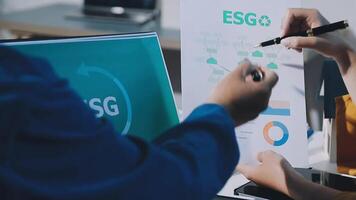 A man is writing on a piece of paper with the word esg video