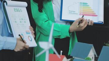 Two people holding papers with an energy efficiency diagram video