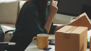 A woman is sitting at a desk with a laptop and a box video