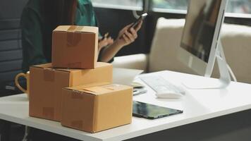 A woman is sitting at a desk with a laptop and a box video