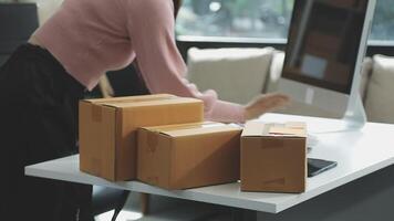 A woman is working on a computer with boxes on a desk video