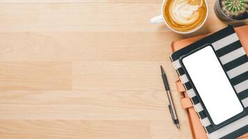 Office desk workspace with blank screen smart phone, notebook, pen and cup of coffee, Top view flat lay with copy space. photo