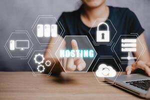 Web hosting concept, Woan using computer and presses his finger on the virtual screen inscription Hosting on desk, Internet, business, Technology and network concept. photo