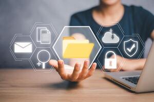 Document Management System, Businesswoman hand holding folder and document icon on virtual screen. .Software for archiving, searching and managing corporate files and information. photo
