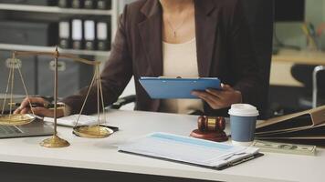 A woman in a business suit is holding a scale and laptop video