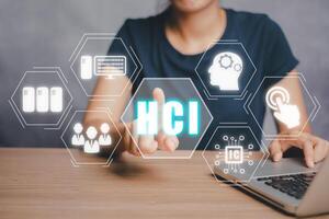 HCI concept, Human computer interaction, Person hand using computer on office desk with HCI icon on virtual screen. photo
