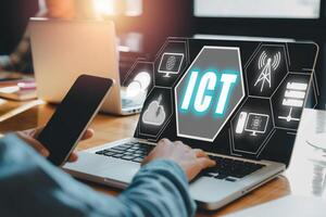 Information and Communications Technology concept, Person hand using laptop computer on desk with ICT icon on virtual screen, Global technology, internet, wifi. photo