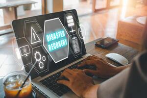 Disaster Recovery concept, Person hand using laptop computer with Disaster Recovery icon on virtual screen. photo