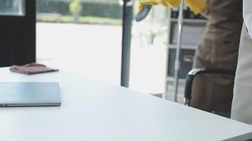 A laptop on a table with a yellow glove on it video