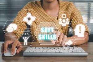 Soft skills training and improvement concept, Woman hand touching VR screen Soft skills icon on office desk workplace background. photo