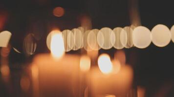 Candles are lit in a dark room with blurred bokeh video