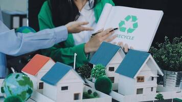Recycle concept with woman and man holding paper with model of house and recycling symbol video