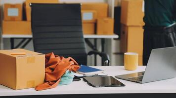 A laptop and boxes on a desk with a man standing behind it video