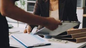 A woman is holding a clipboard while sitting at a desk video