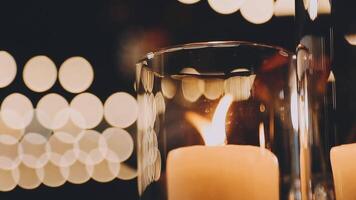 Candles in a glass vase with a blurred background video