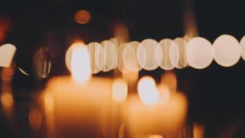 Candles are lit in a dark room with blurred bokeh video