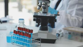 A person in a lab coat is looking at a microscope video