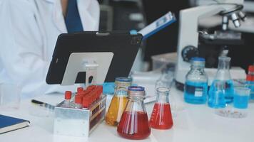 A person in a lab coat is working on a tablet video
