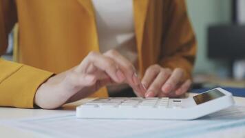 A woman is using a calculator on a desk video