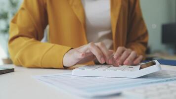 A woman is using a calculator on a desk video