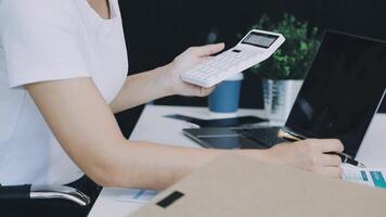 A woman is using a calculator to calculate the cost of a business video