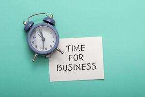 Text Time for Business with blue alarm on azure background photo