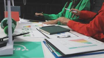 Two people sitting at a table with papers and pens video