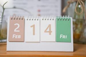 Valentines day concept. February 14 text on desk carlendar on wooden table. photo