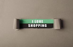 A torn piece of paper with the words I love shopping written on it photo