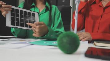 Two people sitting at a table with a tablet computer video
