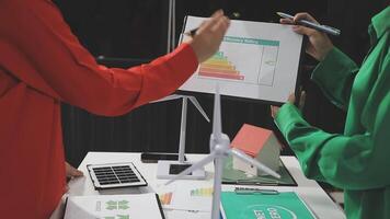 Two people are holding up a chart on a table video