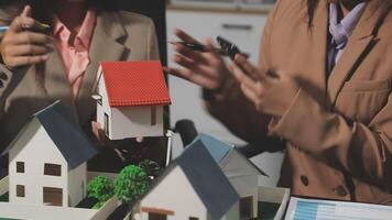 Two people are looking at a model of a house video