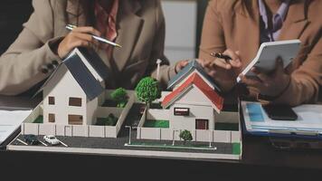 Two people are looking at a model of a house video