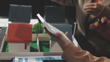 A person is holding a piece of paper with a model of a house video