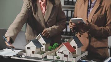 Two people looking at model houses on a table video