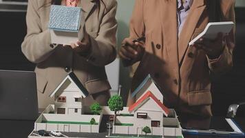 Two women are looking at a model of a house video